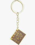 Gold keychain with intricate design on a white background