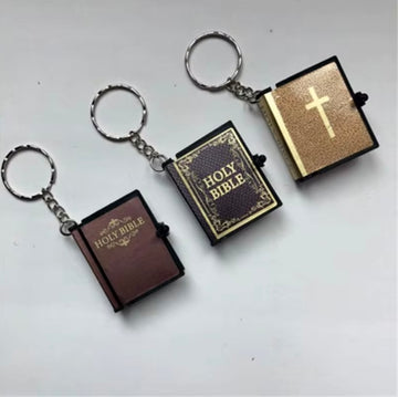 Three keychains shaped like miniature Bibles on a white background
