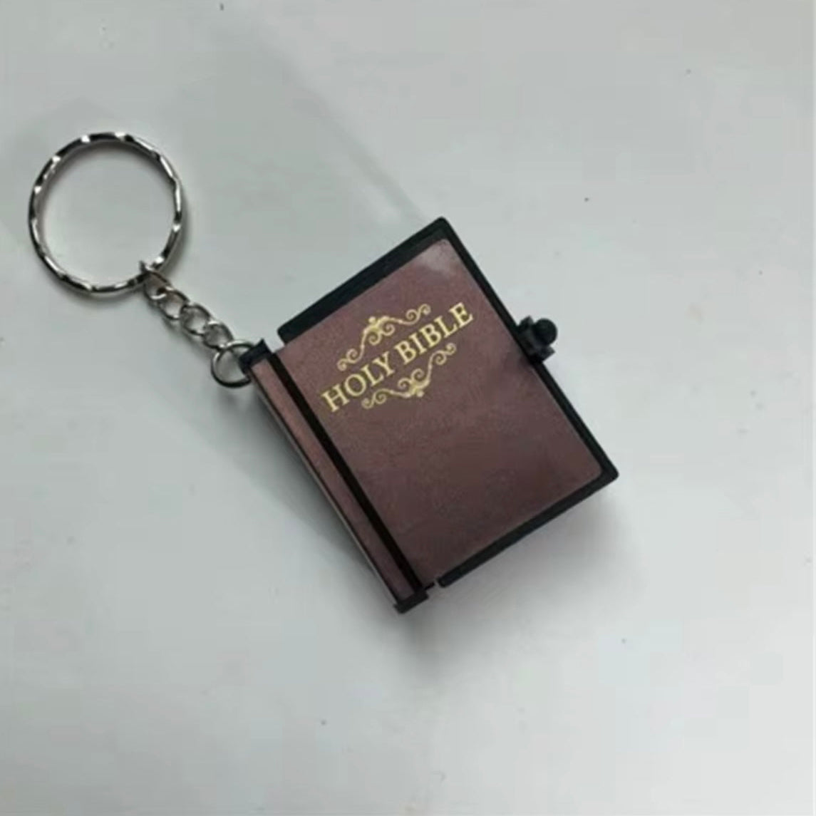Keychain with a miniature book design labeled 'HOLY BIBLE' on a white background
